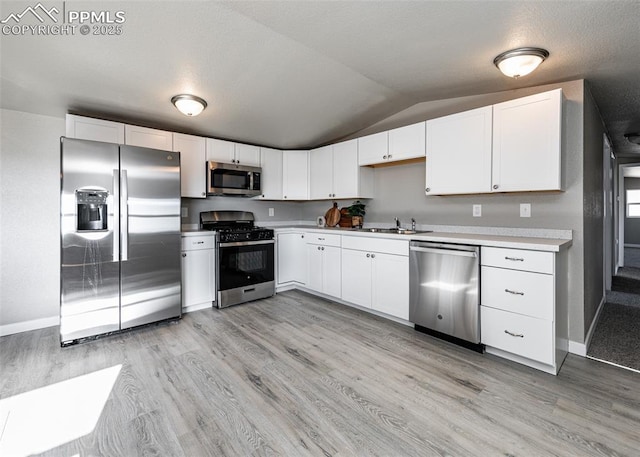 kitchen with white cabinetry, sink, light wood-type flooring, and appliances with stainless steel finishes