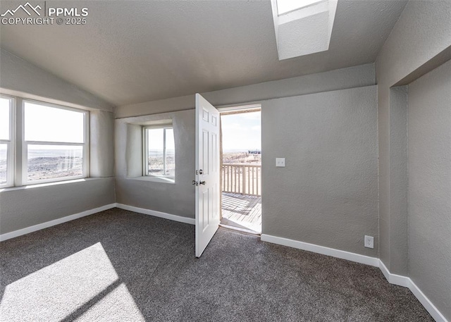 doorway to outside with dark carpet, vaulted ceiling, and a textured ceiling