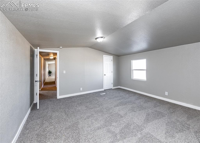 bonus room featuring vaulted ceiling, carpet flooring, and a textured ceiling