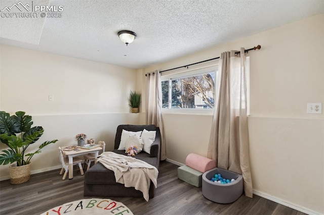 sitting room with dark hardwood / wood-style floors and a textured ceiling