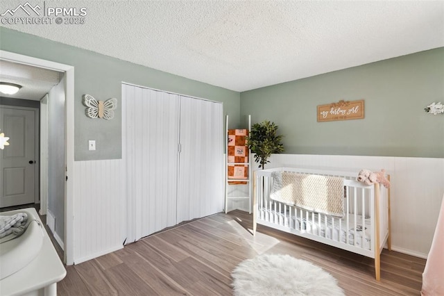 bedroom featuring hardwood / wood-style floors, a textured ceiling, and a closet