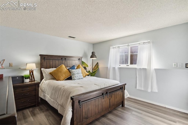 bedroom featuring wood-type flooring and a textured ceiling