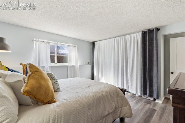 bedroom with hardwood / wood-style floors and a textured ceiling