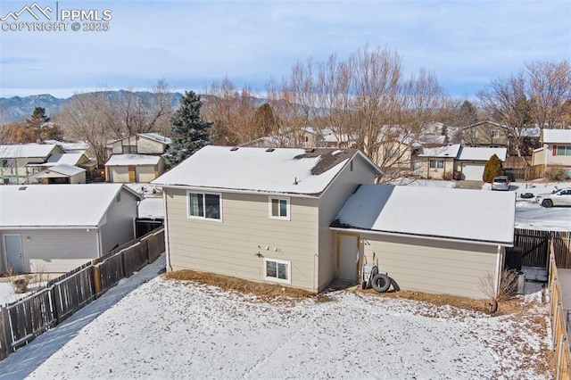 snow covered back of property featuring a mountain view