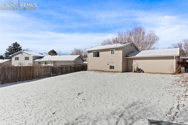 view of snow covered back of property