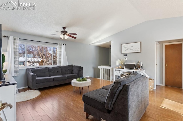 living room featuring ceiling fan, lofted ceiling, hardwood / wood-style floors, and a textured ceiling