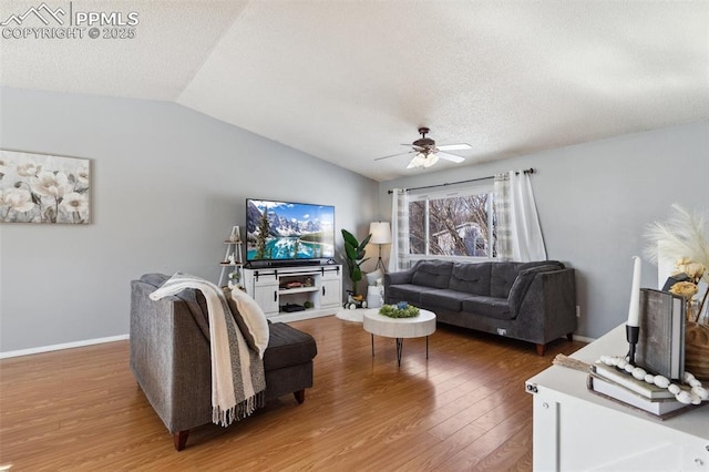 living room with hardwood / wood-style flooring, ceiling fan, vaulted ceiling, and a textured ceiling