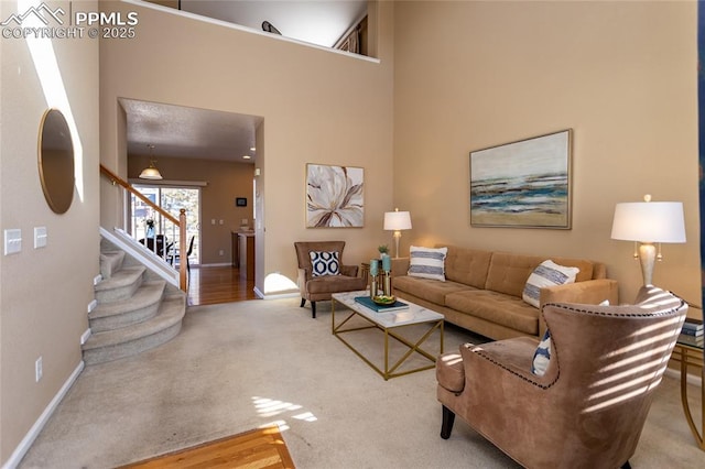 carpeted living room featuring a towering ceiling