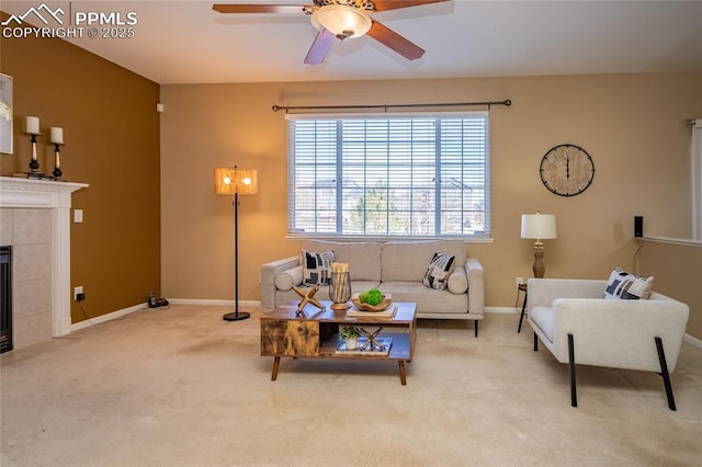 living room with ceiling fan, light colored carpet, and a tile fireplace