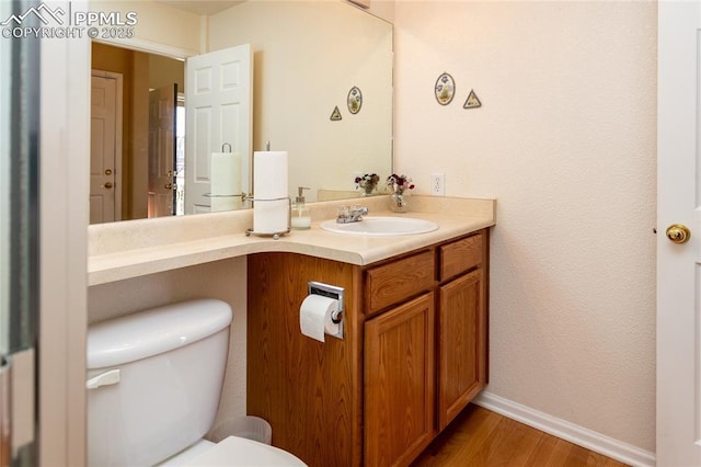 bathroom featuring toilet, vanity, and wood-type flooring