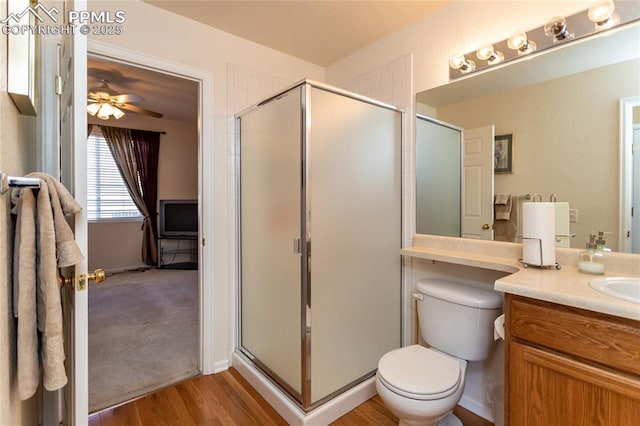 bathroom featuring ceiling fan, a shower with shower door, wood-type flooring, and vanity