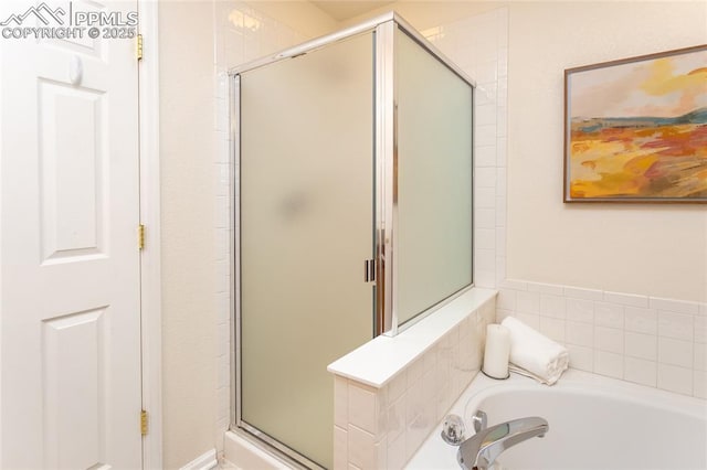 bathroom featuring shower with separate bathtub