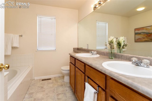 bathroom featuring toilet, tiled tub, and vanity