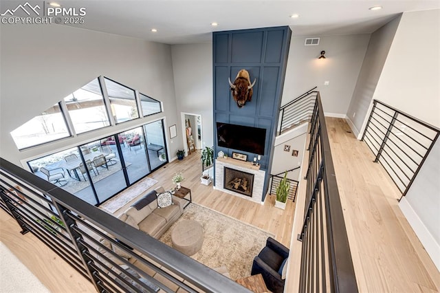 living room with a large fireplace and light hardwood / wood-style flooring