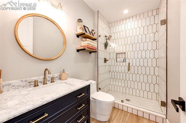 bathroom featuring hardwood / wood-style floors, toilet, a shower with door, and vanity