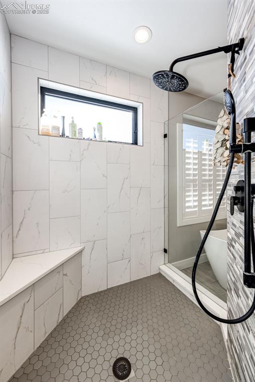 bathroom with tile patterned floors and tiled shower