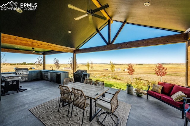 view of patio / terrace with ceiling fan, an outdoor kitchen, a rural view, and a grill