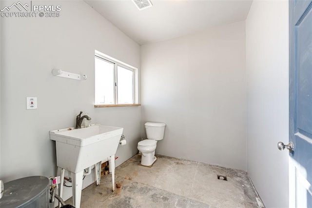 bathroom featuring concrete floors and toilet