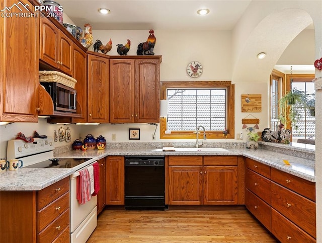 kitchen featuring dishwasher, sink, light stone counters, light wood-type flooring, and electric stove