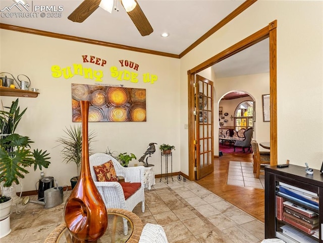 sitting room with ceiling fan, ornamental molding, and light tile patterned floors