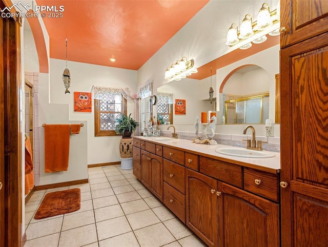 bathroom with tile patterned flooring, vanity, and a shower with shower door