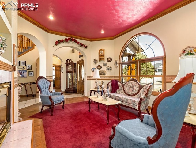 living area featuring ornamental molding, tile patterned flooring, and a tile fireplace