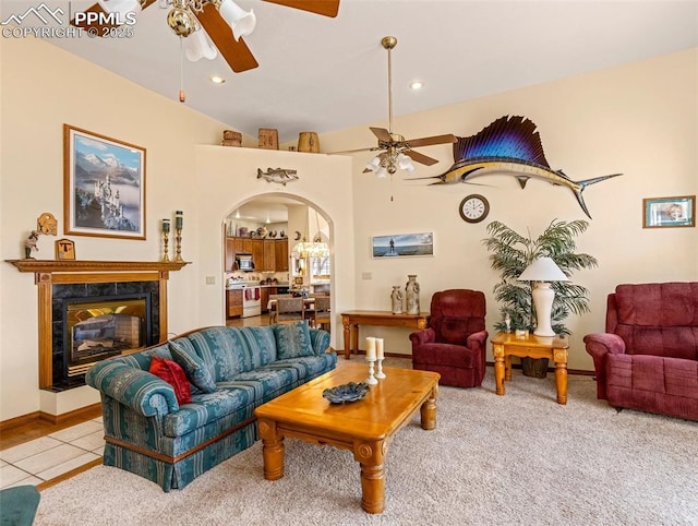 living room with light tile patterned flooring, ceiling fan, and a high end fireplace