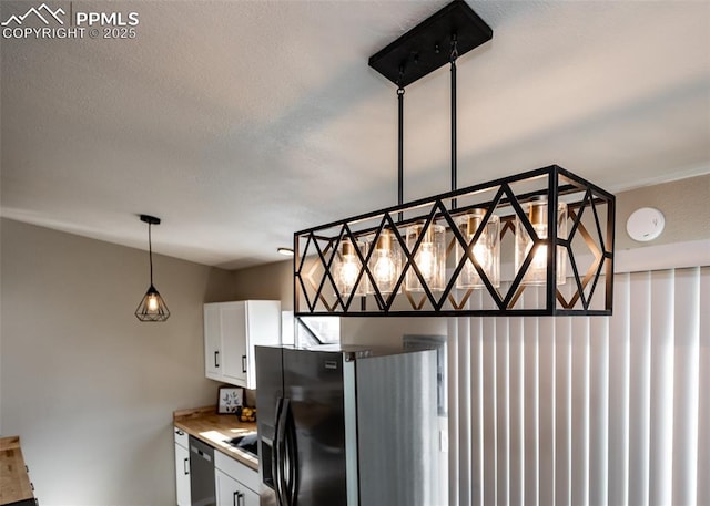 details featuring pendant lighting, white cabinets, and black appliances