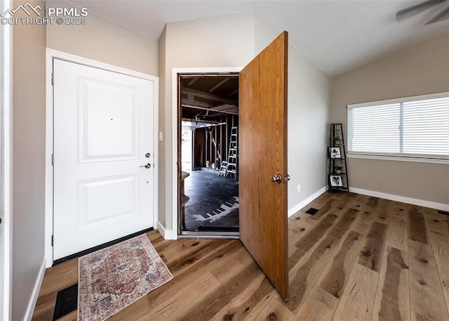 foyer featuring hardwood / wood-style flooring and vaulted ceiling