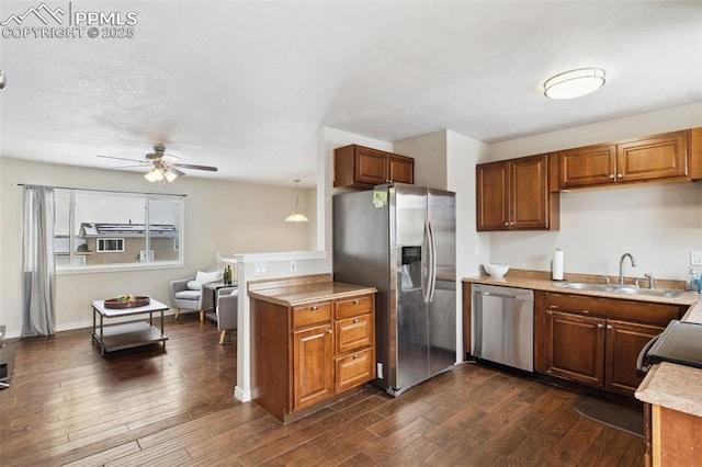 kitchen with decorative light fixtures, sink, dark wood-type flooring, and stainless steel appliances