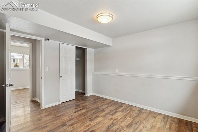 unfurnished bedroom featuring wood-type flooring and a closet