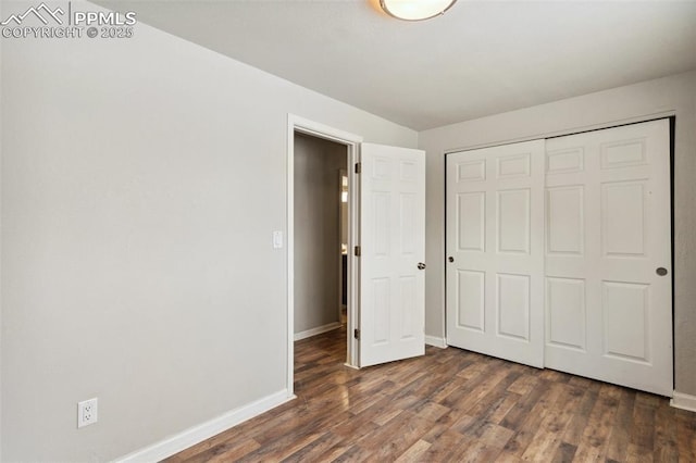 unfurnished bedroom with a closet and dark hardwood / wood-style floors