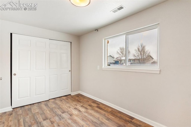 unfurnished bedroom with hardwood / wood-style flooring and a closet