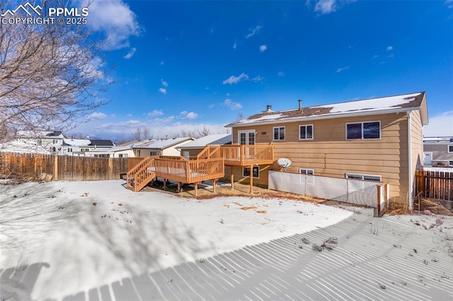 snow covered rear of property featuring a deck