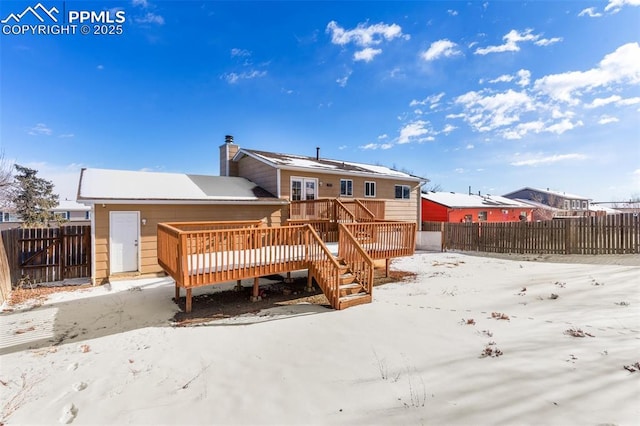 snow covered rear of property featuring a deck