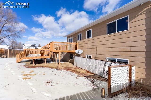 snow covered house featuring a deck