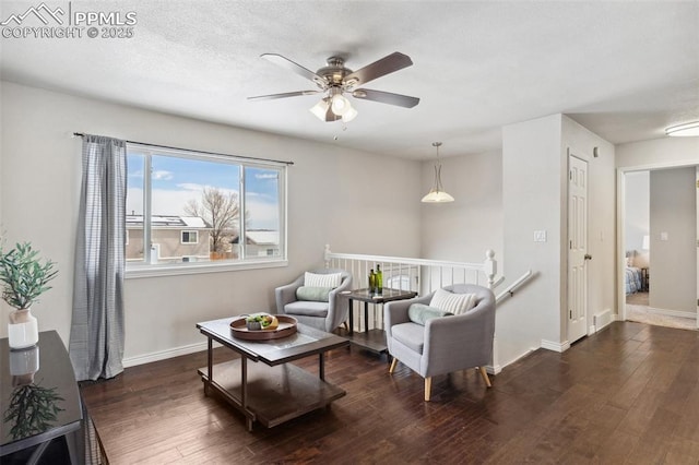 living area featuring dark wood-type flooring and ceiling fan