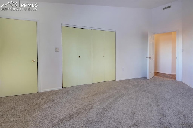 unfurnished bedroom featuring a closet and light carpet