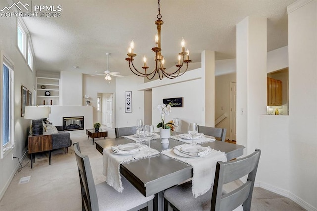 carpeted dining room with ceiling fan with notable chandelier