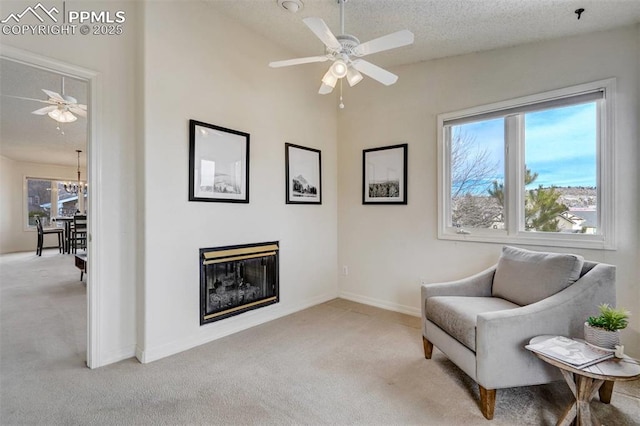 living area with plenty of natural light, light carpet, and a textured ceiling