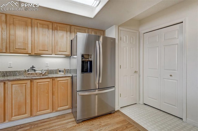 kitchen featuring light brown cabinetry, light hardwood / wood-style flooring, and stainless steel refrigerator with ice dispenser