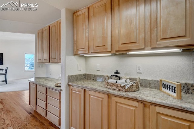 kitchen featuring light stone countertops, light brown cabinets, and light hardwood / wood-style floors