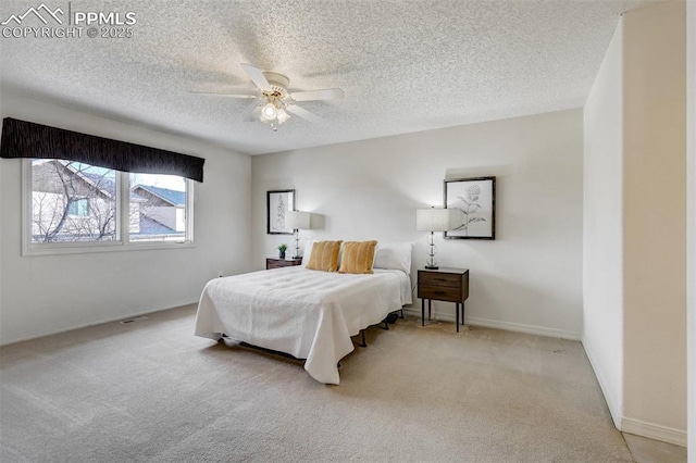 carpeted bedroom with ceiling fan and a textured ceiling