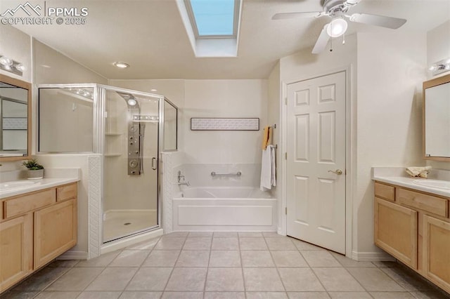 bathroom with independent shower and bath, vanity, tile patterned floors, and a skylight