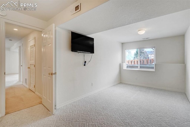 spare room featuring light colored carpet