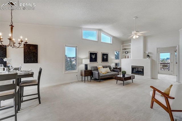 carpeted living room with built in shelves, vaulted ceiling, a textured ceiling, and ceiling fan with notable chandelier