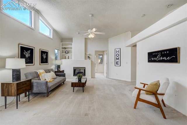 carpeted living room featuring ceiling fan, high vaulted ceiling, and a textured ceiling