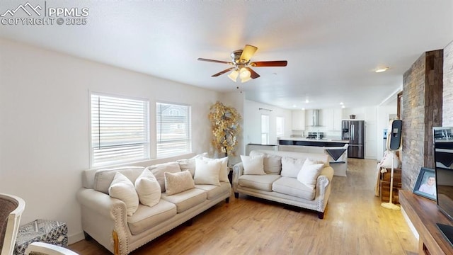 living room with ceiling fan and light hardwood / wood-style flooring