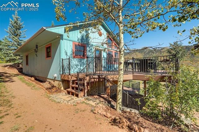 rear view of house featuring a wooden deck