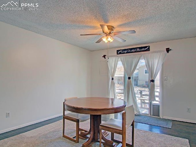 dining room featuring ceiling fan, dark wood-type flooring, and a textured ceiling